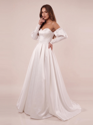 Side pose of satin off-shoulder wedding dress with puff sleeves and flowing A-line skirt